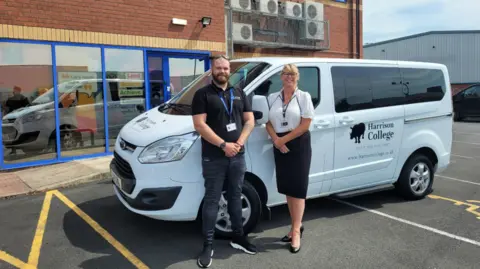 Harrison College Two people standing by a Harrison College minivan 