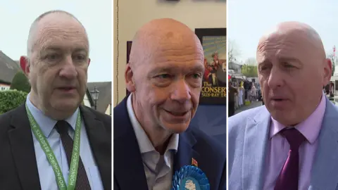 Close up of three men in a composite image. They are all middle aged and bald and wearing suit jackets. One is wearing a blue rosette. 