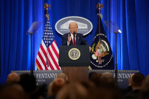 Getty Images Donald Trump speaks at the Department of Justice last week. He pledged to fight gang violence and step up deportations.