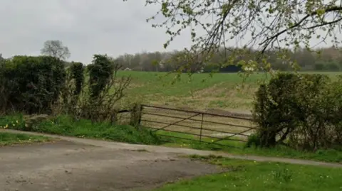 Google A gate with farmland beyond