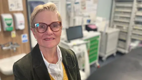 Dr Katharine Halliday the Clinical Lead for the Community Diagnostic Centre wearing a green jacket, yellow jumper and white blouse. Pictured in the MRI suite at the Queen's Medical Centre Nottingham