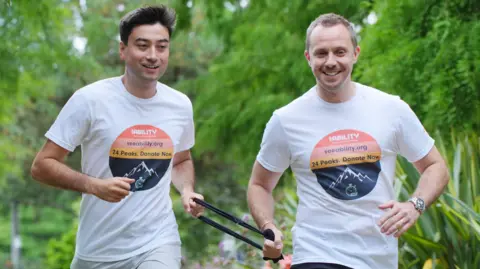 Michael Smith (left) and Jack Stacey running, both holding a band to keep them in tandem