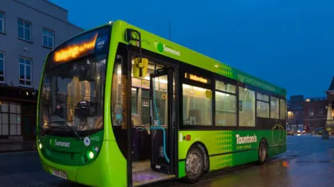 Buses of Somerset A green bus lit up on a darkened street