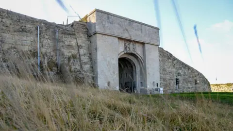 Getty Images A general view of HMP The Verne, a stone arch built into a stone wall, which serves as the entrance to the prison.