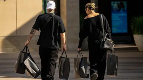 Shoppers carry Alo bags in Walnut Creek, California, US, on Thursday, Feb. 5, 2026. 