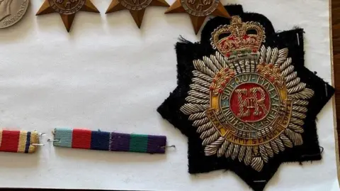Gloucestershire Police A close up picture of a black medal with the royal crest on it.
