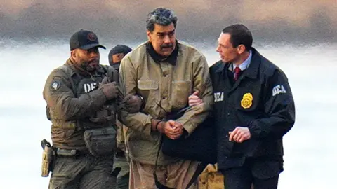  Nicolas Maduro is seen in handcuffs after landing at a Manhattan helipad, escorted by heavily armed Federal agents as they make their way into an armored car en route to a Federal courthouse in Manhattan on January 5, 2026 in New York City.