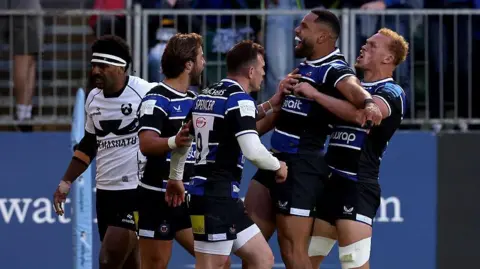 Joe Cokanasiga (second right) holds his arms out in celebration as Bath team-mates jump around him