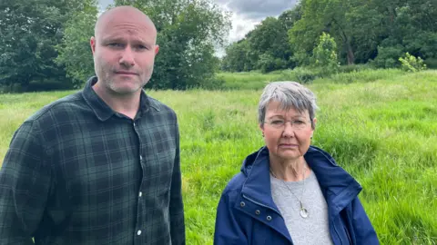 Mr Alexander and Ms Nottage standing in the grass on the old golf course