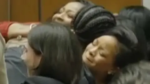 An emotional Rihanna and A$AP Rocky embrace alongside family members