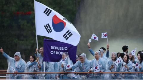 Paris 2024 Olympics - Opening Ceremony - Paris, France - July 26, 2024. Athletes of South Korea aboard a boat in the floating parade on the river Seine during the opening ceremony