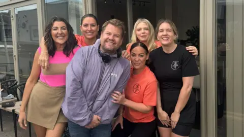 Laura Davenport Laura Davenport (far left) and Scoop ice cream store workers pose with James Corden (centre) outside the shop. 