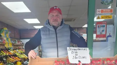 Fresh N Fruity A man in front of strawberries 