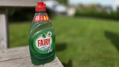 A green bottle of washing up liquid, signed by the rescue team