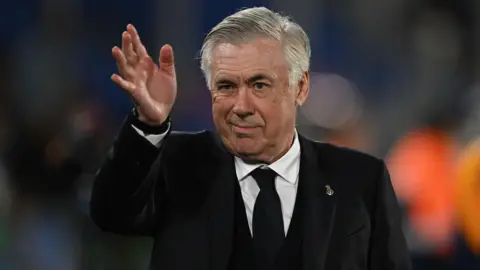 Carlo Ancelotti waves to the crowd during Real Madrid's defeat to Barcelona in El Clasico