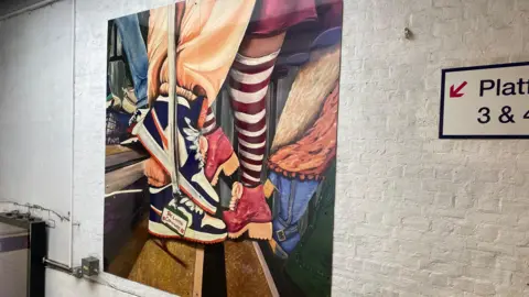 Network Rail A painting on the wall of people depicted below the leg
