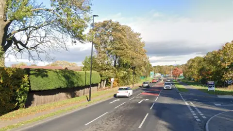 A bypass road, with a third lane in the middle for right turns into the adjacent junction.