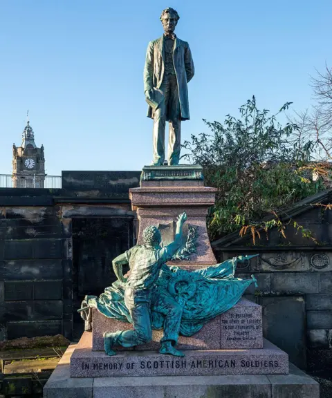 Alamy The Civil War memorial in Old Calton Burial Ground, depicting Abraham Lincoln. The Balmoral clock tower is in the background.