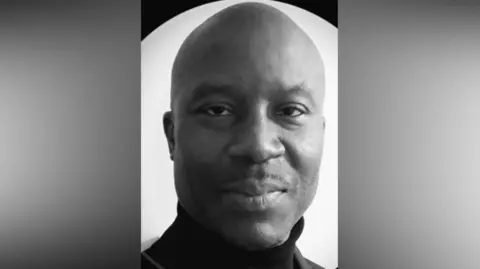 A black and white photo of Simon Whyte in a black roll neck jumper.