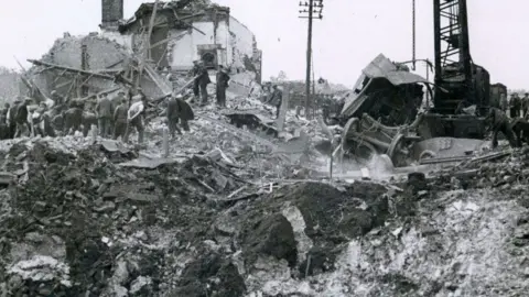 Men working around the rim of a large crater caused by a munitions wagon explosion, Soham 1944