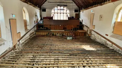 PA Media Broken wooden floorboards across a theatre space