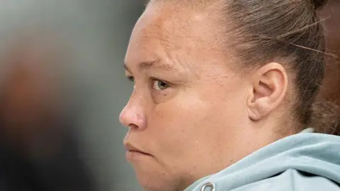 Kelly Smith, wearing a greyish sweater, listens on as her sentence is read out in the Western Cape high court