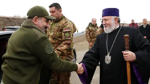 Press office of the Government of Armenia Armenia's prime minister shakes hands with the head of Church.