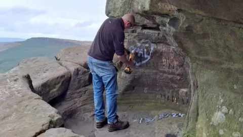 Graffiti being removed from a cave in the Peak District