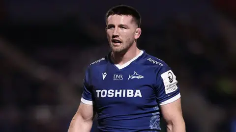 Tom Curry standing on the pitch during Sale v Sharks in the Champions Cup in January