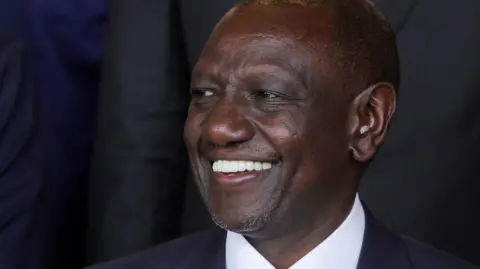 Kenya's President William Ruto in a black suit and white shirt