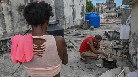A man cooks with firewood during a blackout in Havana on May 13, 2026. 