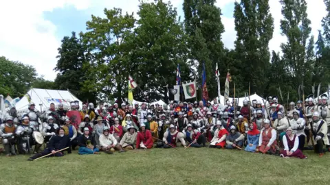 Pat Patrick A large group in medieval costume posing for a photo outside