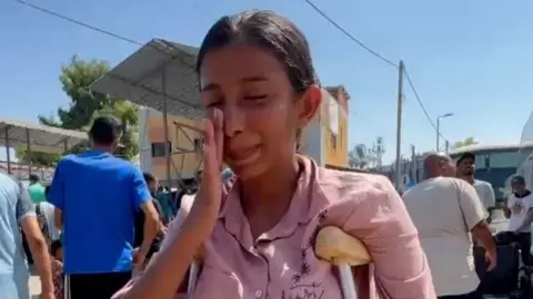 Sara Marzouk wipes away a tear as she waits to join a medical evacuation out of Gaza (30/07/24)