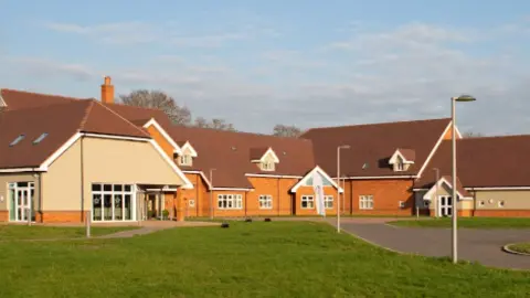 Alexander Devine Children's Hospice The red brick and beige cladded building of the hospice with greenery outside the front.