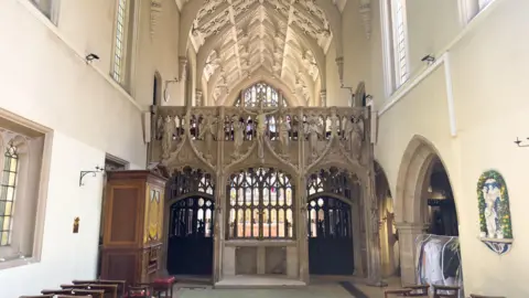 Knight Frank A small chapel with white walls and a stone depiction of Christ on the cross.