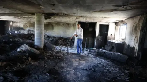 'Israeli forces took over my home and then they set it on fire' A man stands inside a burnt room.
