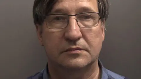 Reuters/Humberside Police A mugshot of a middle aged man with glasses, brown hair and a checked blue shirt