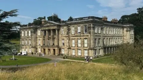 A Grade I listed house with a green space around it.