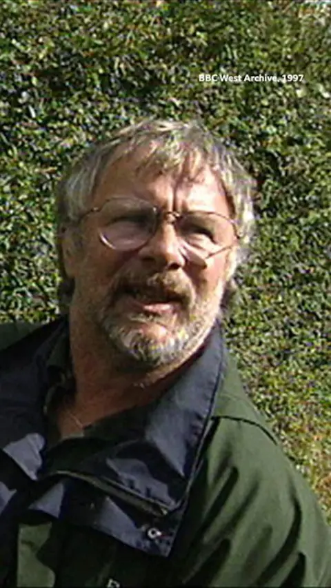 A man looking at the camera with glasses on.