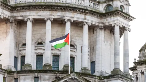 Caoimhin McNulty/PA A Palestinian flag flying from Belfast City Hall.