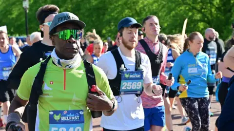 Pacemaker Several runners, one of them black, the rest white, taking part in the 2025 Belfast Marathon 