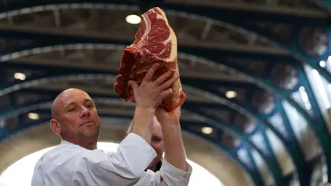PA Media Seller holds up prime cut of meat