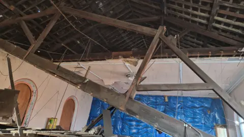 Julian Marriott A section of the ceiling has gone revealing the inside of the roof rafters and a beam still attached at one end but detached from the other