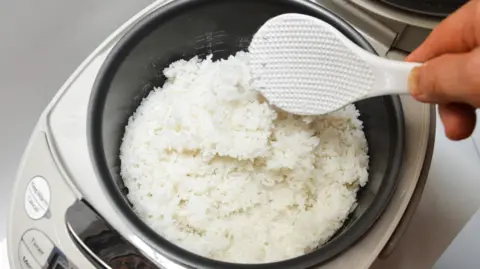 Getty Images A bowl of rice in a rice cooker.