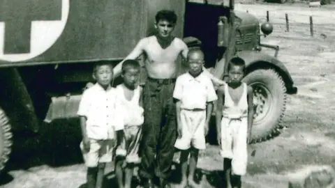 Albert standing with four Korean children