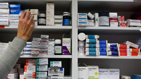 A pharmacist stocking shelves.