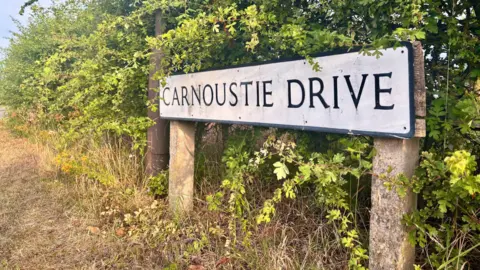 Bedfordshire Police A road sign shows Carnoustie Drive in Great Denham, stood near a large green shrub