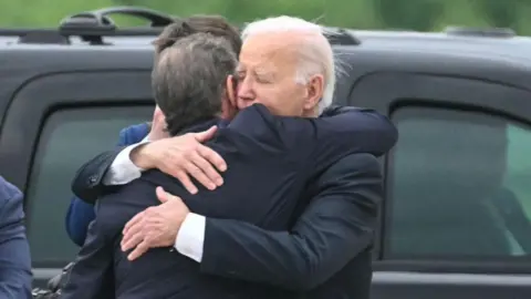US President Joe Biden hugs his son Hunter Biden on an airport tarmac in Delaware