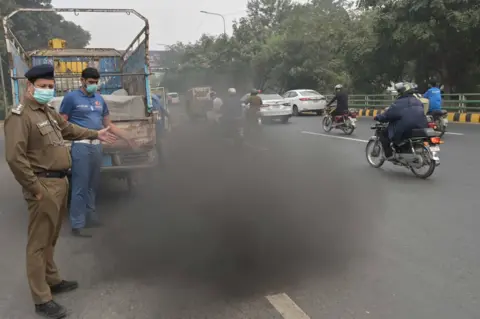 A HUSSAIN/EPA-EFE Pakistani security officials check for vehicles emitting smoke in Lahore