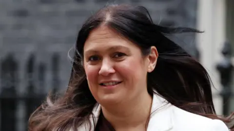 Culture Secretary Lisa Nandy smiles as she looks towards the camera. She has long brown hair and is wearing a white jacket